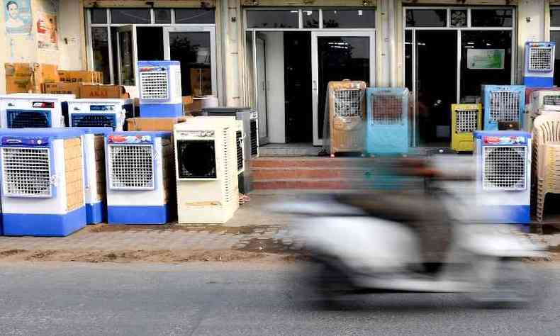 Lojas de eletrodomsticos expem aparelhos de ar condicionado nas caladas(foto: Money SHARMA / AFP)