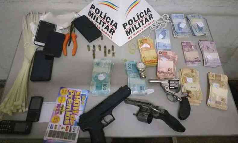 Dois revlveres, uma rplica de arma, dinheiro e outros materiais foram apreendidos(foto: Polcia Militar/Divulgao)