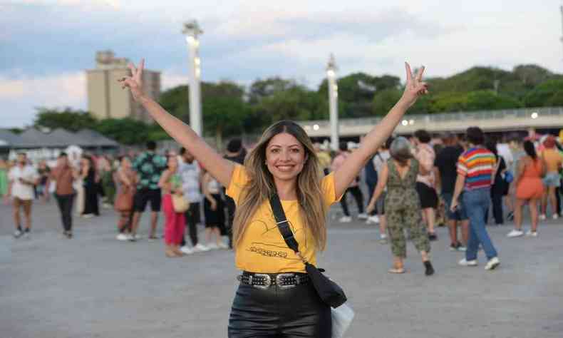 Com camiseta amarela, Camila Cesrio ergue os braos