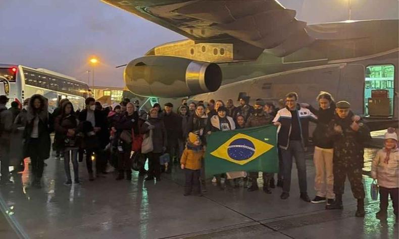 Brasileiros posam para foto em frente ao avio da Fora Area Brasileira na Polnia