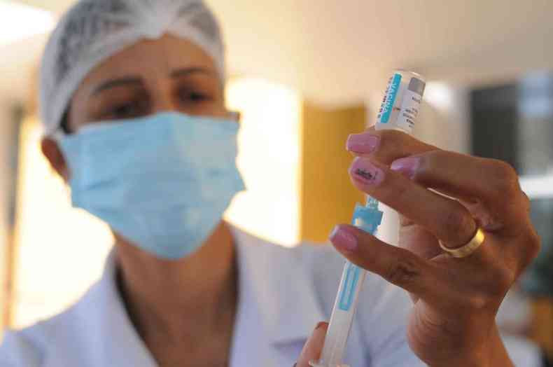 Enfermeira segura seringa de vacina 