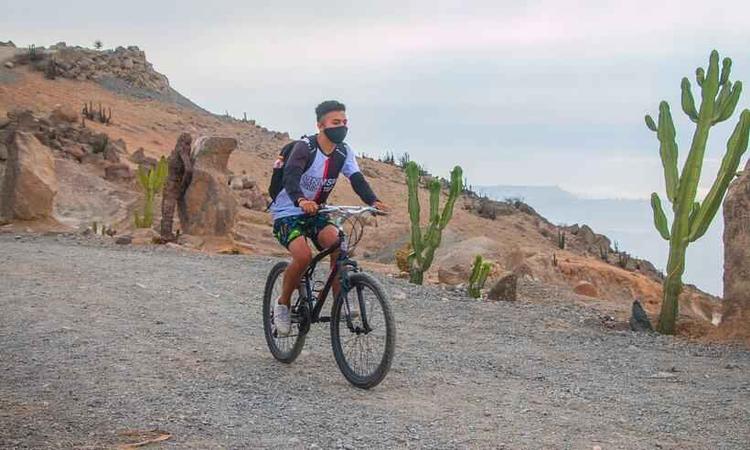 rapaz anda de bicicleta usando mscara