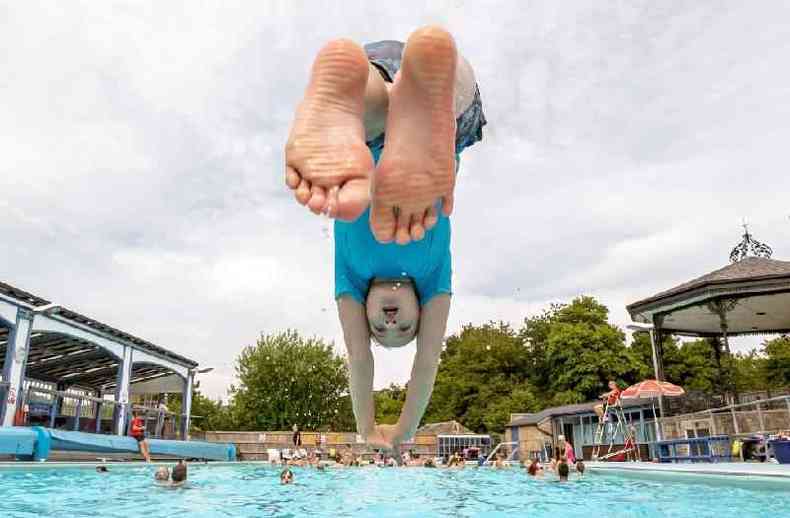 Menino mergulhando de cabea na piscina