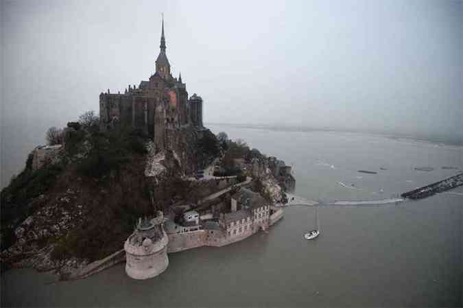 Vista area do Monte Saint-Michel rodeado pelo mar durante a mar cheia (foto: AFP PHOTO / DAMIEN MEYER )