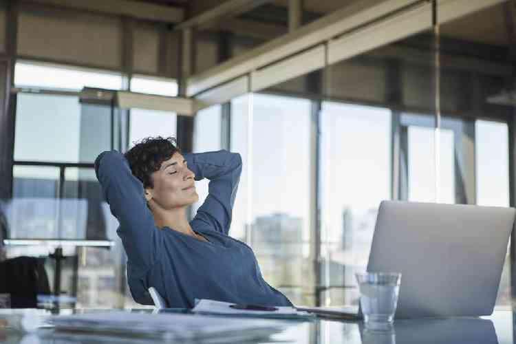 Mulher sentada relaxada em frente a laptop no escritrio