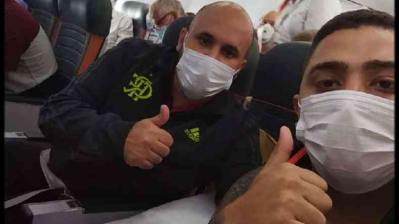 Josimar e Douglas em selfie fazendo gesto da joinha, de dentro do avião