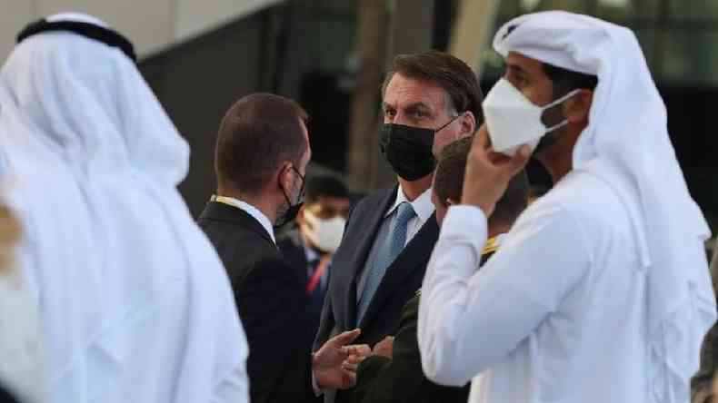 Bolsonaro de mscara, entre homens com trajes tpicos dos Emirados rabes
