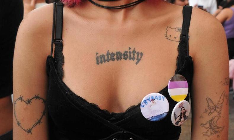 14 de Julho é Dia Internacional das Pessoas Não-Binárias(foto: Túlio Santos/EM/D.A Press) Foto de um busto de uma pessoa não-binária. Elu tem pele clara e várias tatuagens pelo corpo. Na blusa, usa um botton com a bandeira não-binária com as cores amarelo, branco, roxo e preto.