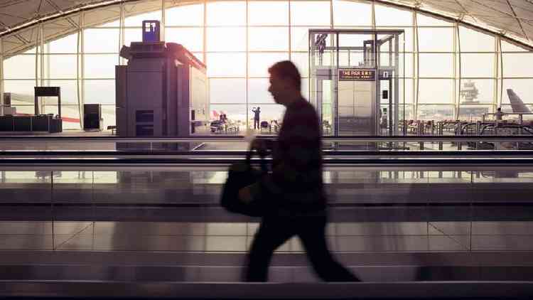 Homem andando no aeroporto de Hong Kong