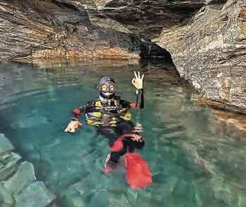 Jornalista Daniela Filomeno dentro do lago formado na caverna da Mina da Passagem, na cidade mineira de Mariana 