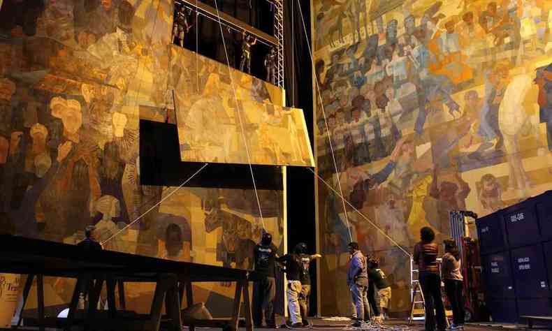 Homens montam o imenso painel Guerra e Paz, de Portinari, no Cine Brasil, em BH