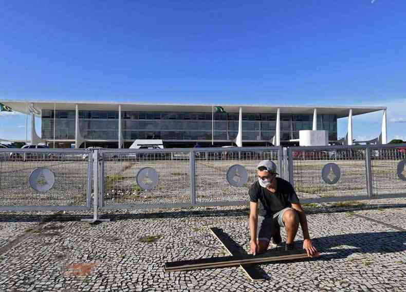 Manifestante contrrio  atuao de Jair Bolsonaro na crise do coronavrus instala cruz em frente ao Palcio do Planalto(foto: Evaristo S/AFP)