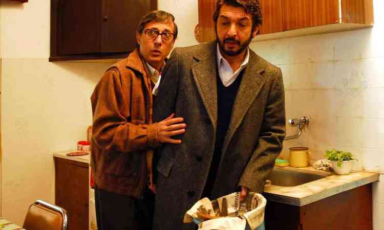 Dois homens esto na cozinha, um segura lata de lixo, no filme O segredo dos seus olhos