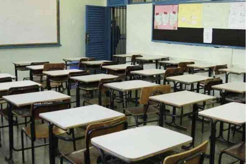 Sala de aula com mesas e cadeiras vazias 