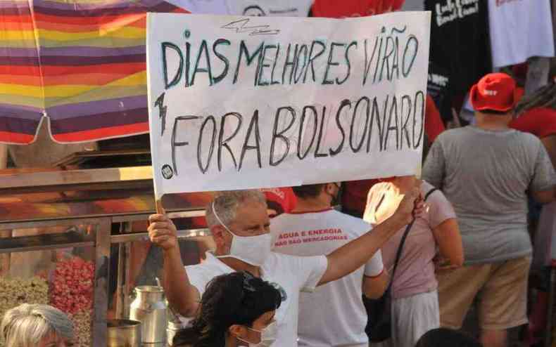 manifestante exibe cartaz, em protesto contra Bolsonaro, com os dizeres 'Dias melhores viro. Fora, Bolsonaro'