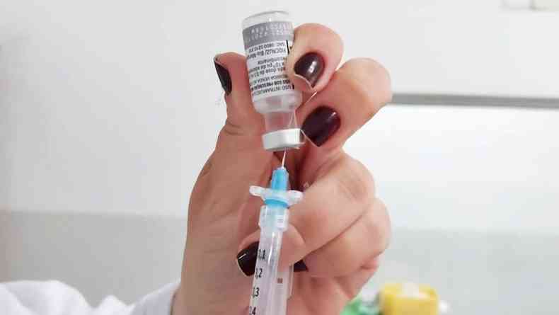 Profissional da área da saúde prepara seringa para aplicação de vacina