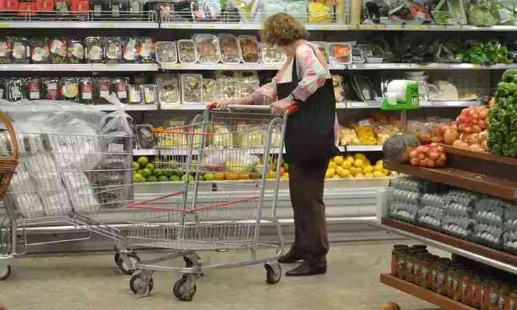 Dona de casa fazendo compras no supermercado com carrinho