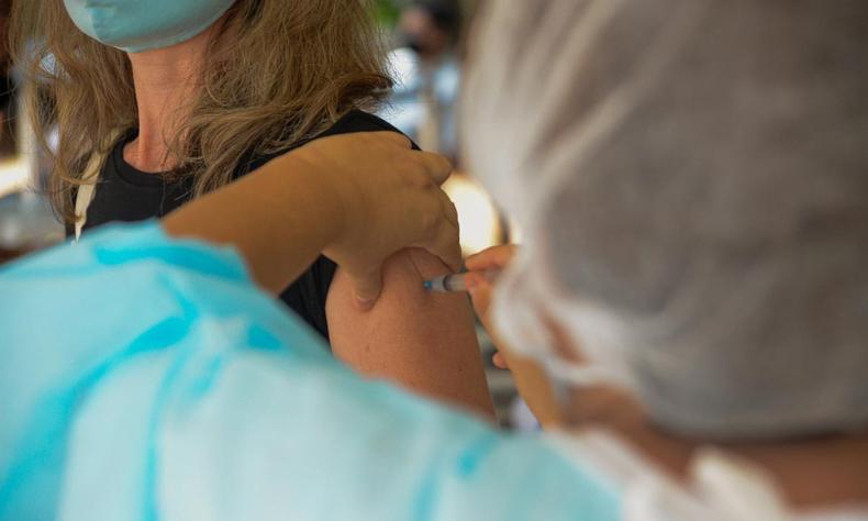 Ao todo, 182.590 pessoas foram imunizadas com as duas doses ou dose única da vacina contra a COVID(foto: Dirceu Aurélio/Imprensa MG) Mulher é vacinada contra COVID-19
