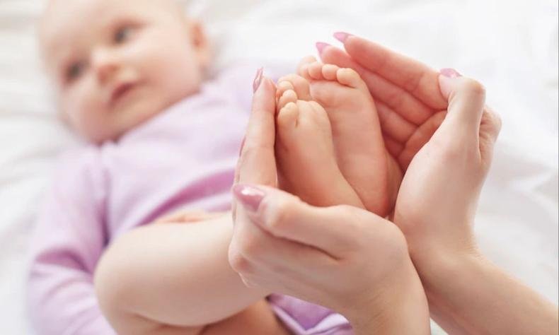 A legislação brasileira estabelece que os cartórios podem se recusar a fazer o registro de um nome que cause constrangimentos à criança(foto: Freepik) mãe segurando o pé de um bebê