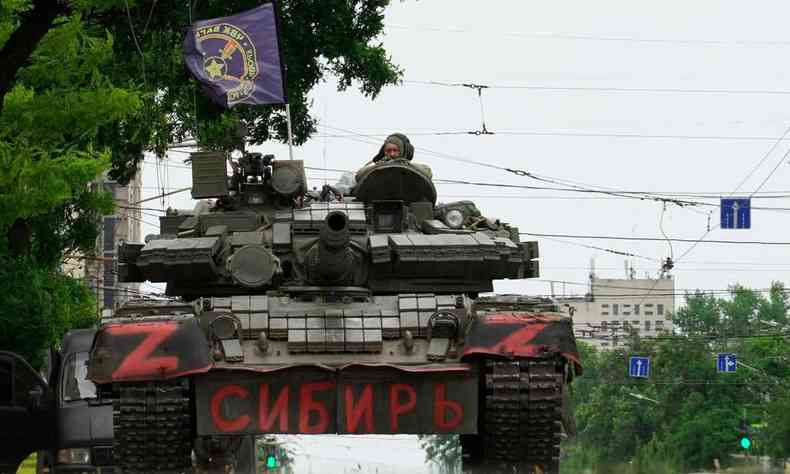 Membros do grupo Wagner sentam-se em cima de um tanque em uma rua na cidade de Rostov-on-Don, em 24 de junho de 2023