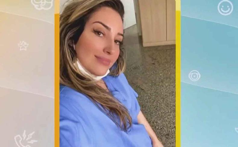 Amanda  uma mulher loura, de cabelos compridos, e usa jaleco