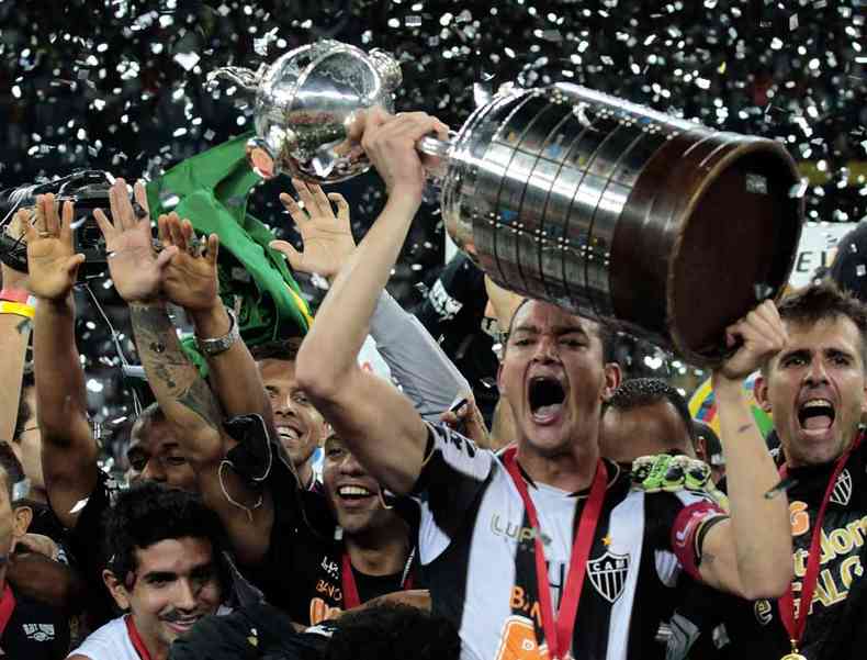 O zagueiro e capitão Réver levanta a taça do título da Libertadores de 2013 diante do Olimpia, do Paraguai