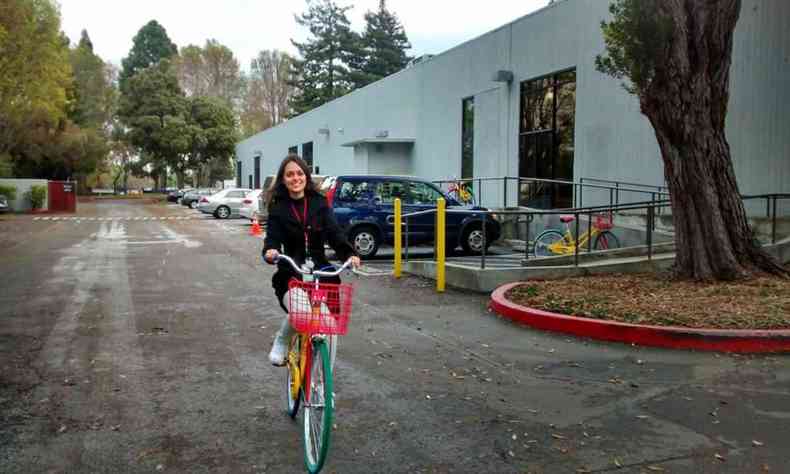 Luciana pedalando uma bicicleta, na sede do Google nos EUA