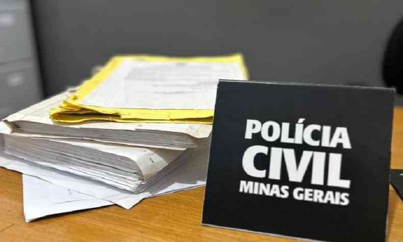 mesa com processos e placa da polcia civil