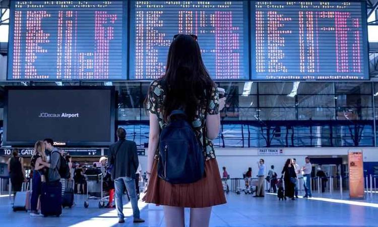 moa diante de painel de voos em um aeroporto