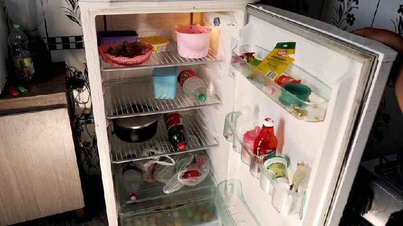 Geladeira da casa onde Vitria vive com o marido e a filha de 1 ano quase vazia, apenas com duas garrafas e poucos elimentos, como temperos e tomates