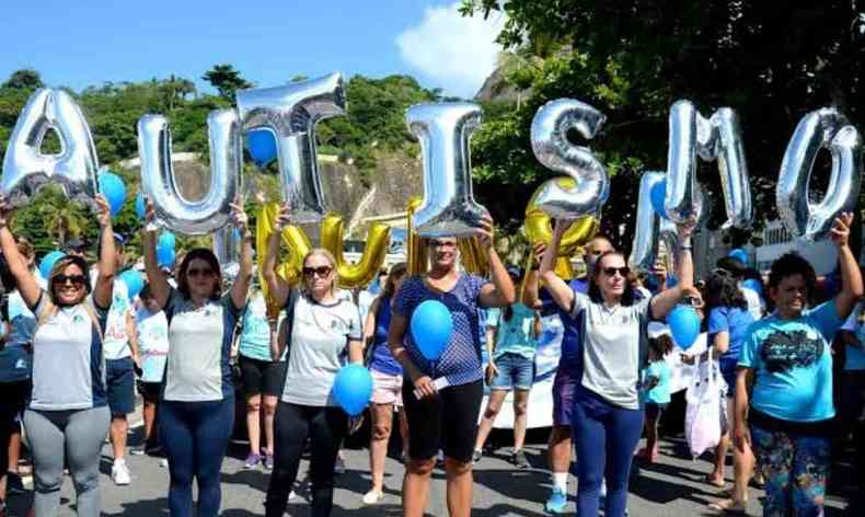 Passeata da Fundação Mundo Azul. Ao centro pessoas com balões formando a palavra autista.