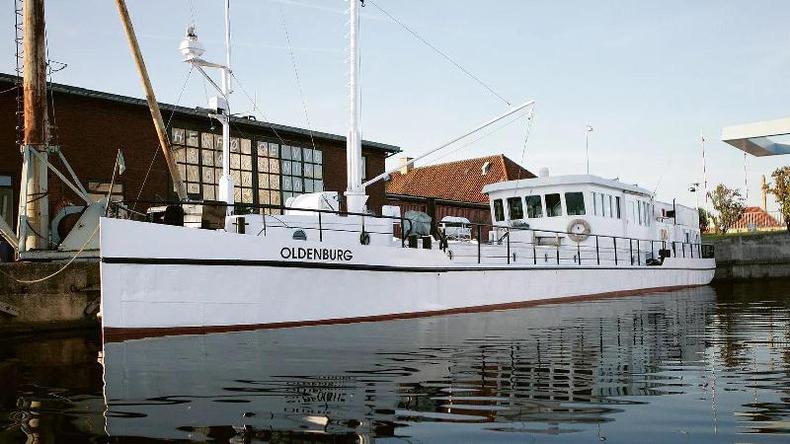 Fotografia colorida mostra um barco antigo e branco em um rio