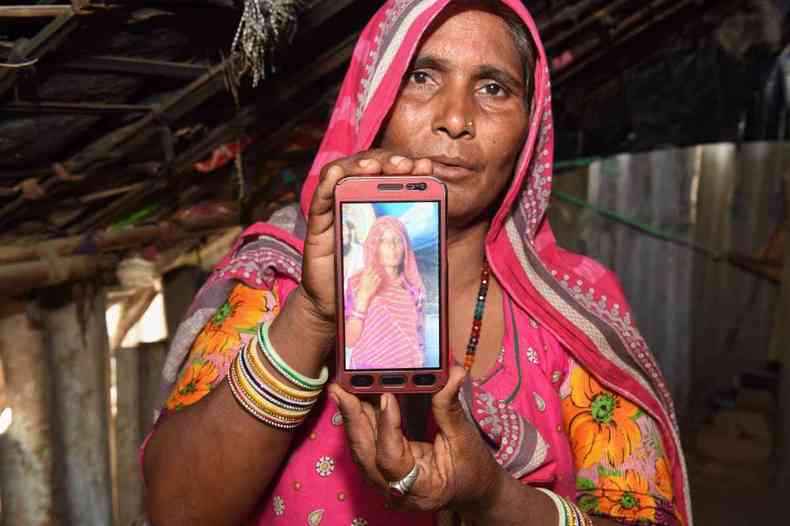 Mohinidevi Nath mostra a foto da prima Shantadevi Nath, morta depois que um boato a acusou de planejar o sequestro de crianas(foto: SAM PANTHAKY/AFP)