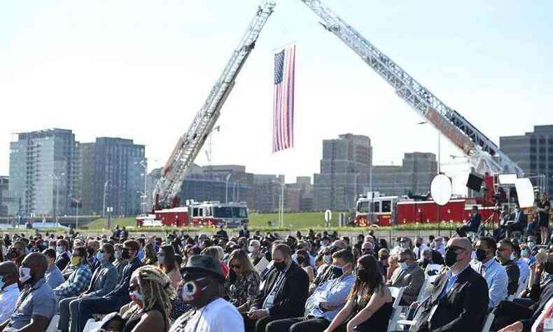 Bandeira americana hasteada por caminhes de bombeiros em cerimnia para homenagear os mortos no atentado de 11/9/2001 
