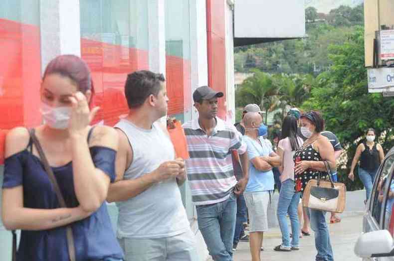 Pessoas em fila de Nova Lima usm mascaras e outras no