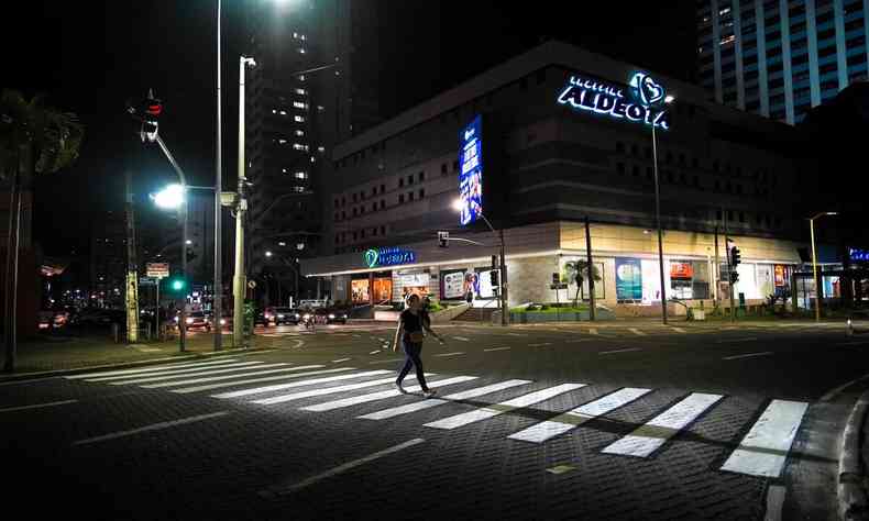 Faixa de trnsito iluminando os pedestres com um poste de luz que fica no rumo da faixa