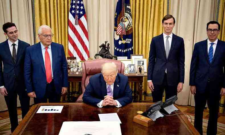 Na presena do embaixador de Israel, David Friedman (esquerda), e de membros do governo americano, Trump anunciou o histrico acordo de paz(foto: Jack Guez/AFP)