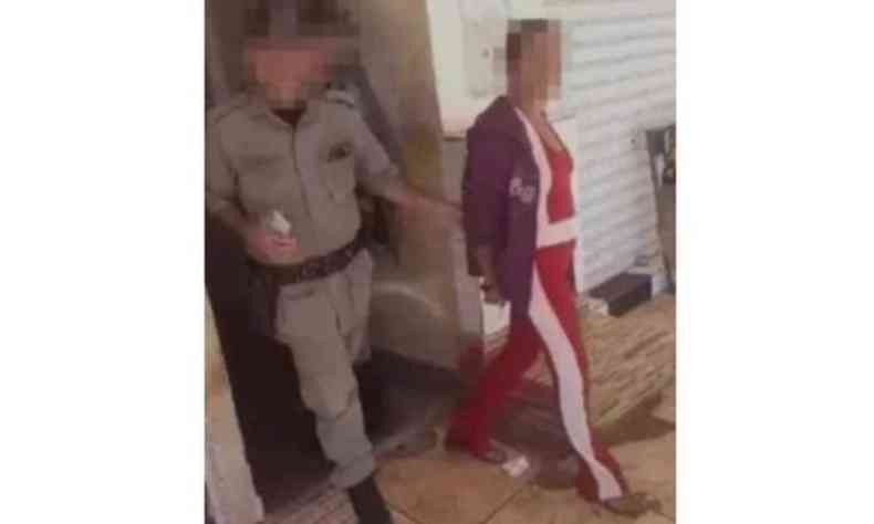 Foto retirada de vdeo mostra policial conduzindo a mulher; imagem est distorcida para evitar identificao