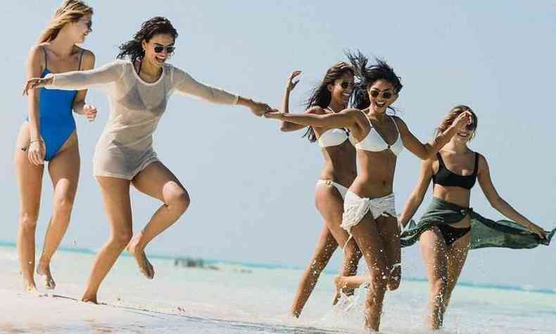 Mulheres correm na praia em cena da srie Fyre festival: fiasco no Caribe