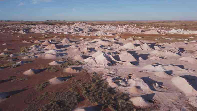 Foto aérea mostra aparentes montes de areia em ampla área desértica