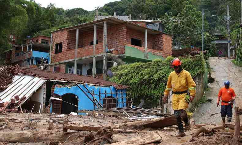 Bombeiros passam prximo a casas destrudas pelo temporal em maio a lama