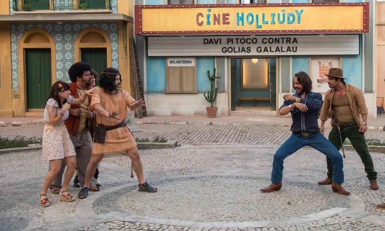 Atores ameaam brigar, na praa, tendo ao fundo a fachada do Cine Hollidy, 