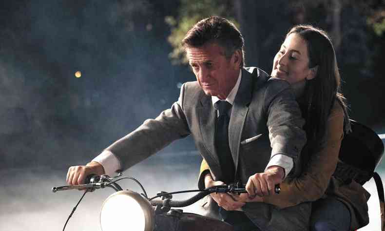 Atores Sean Penn e Alana Haim sorriem andando de moto no filme Licorice Pizza