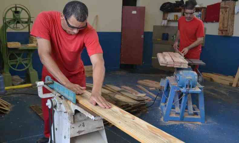 Presos trabalham em salo cortando madeira