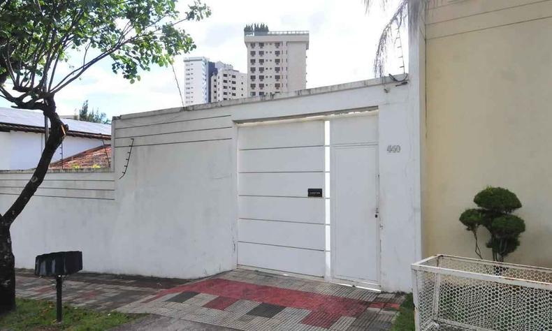 Casa com muros altos e um grande porto branco