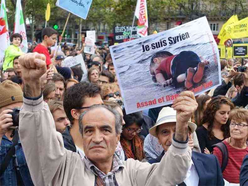 Homem mostra cartaz com os dizeres 'Eu sou srio' durante protesto em solidariedade aos migrantes na Praa da Repblica, em Paris (foto: AFP PHOTO / GUILLEMTTE VILLEMIN )