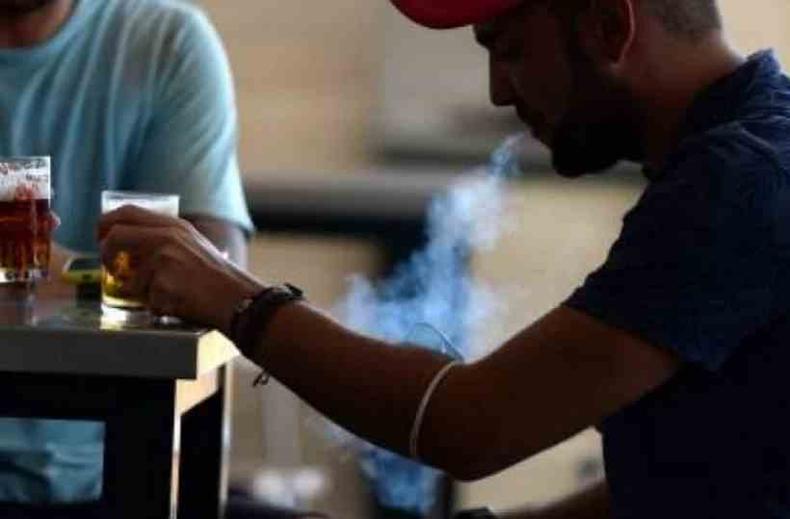 (foto: Cristina/Quicler) Homem fumando e bebendo cerveja