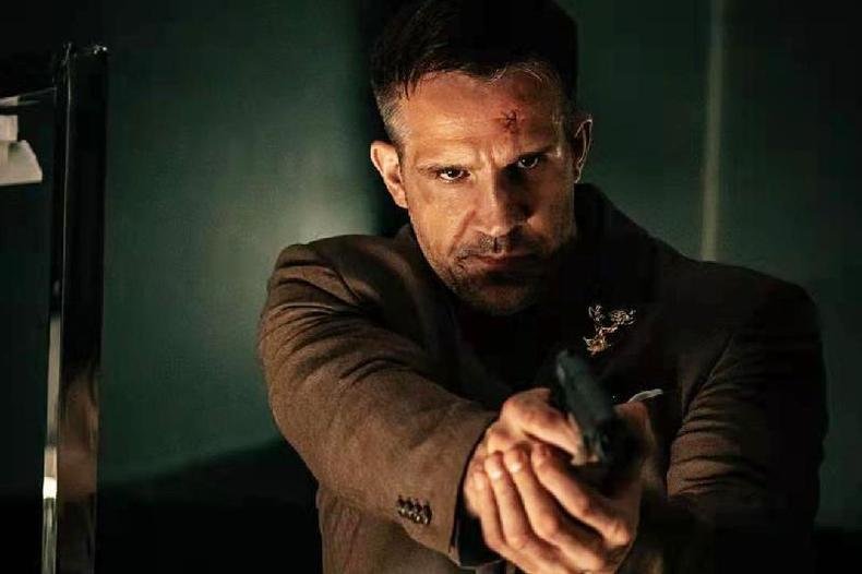 Kevin Lee, um homem branco, forte, segura uma arma e est� com a testa machucada