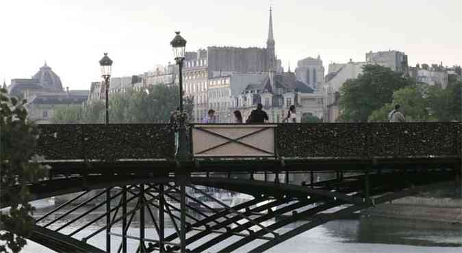 Tapume tampa a parte em que a estrutura cedeu na ponte sobre o Sena (foto: AFP PHOTO /JACQUES DEMARTHON )