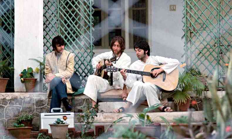 Ringo Starr olha para John Lennon e Paul McCartney tocando violão, em eremitério na Índia